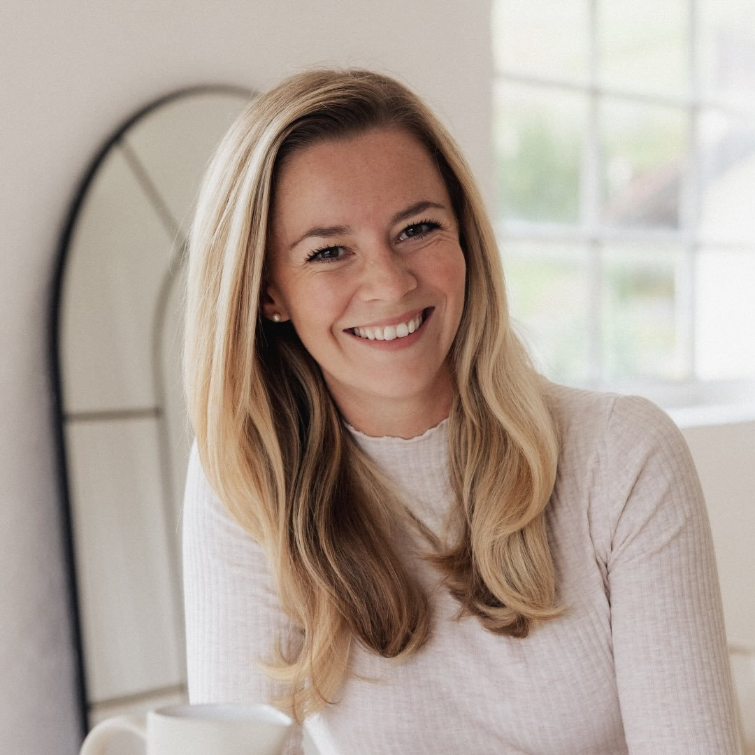 Carolin Hessenberger lächelt in einem hellen Raum mit einer Tasse in der Hand